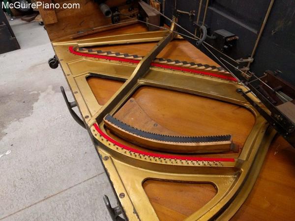 In preparation for resstringing: old strings and tuning pins have been removed, new understring cloth has been installed, tuning pin bushings have been removed, and the plate has been cleaned. 