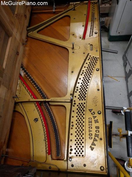 In preparation for resstringing: old strings and tuning pins have been removed, new understring cloth has been installed, tuning pin bushings have been removed, and the plate has been cleaned. 
